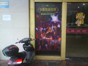 A poster for World of Warcraft outside an internet cafe in Shanghai. The low cost cafes allow access to the internet for Chinese citizens without computers and give gamers a place to play.