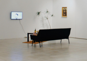 The original exhibition of "When you think about painting do you think about something like this" features a living room setup within the exhibit space.